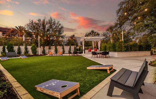 a patio with tables and chairs and a lawn