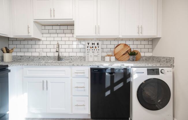 a white kitchen with white cabinets and a washing machine  at Venue at Carrollton, Georgia