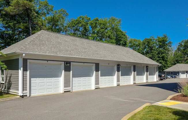 A building with a grey roof and white garage doors.