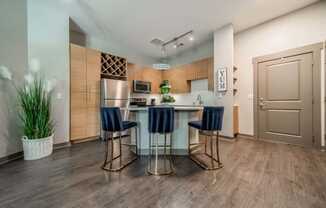 a kitchen with a bar with three stools