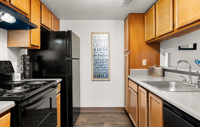 a kitchen with black appliances and wood cabinets