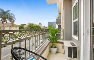 a balcony with a chair and a potted plant