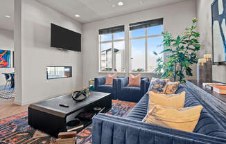 a living room with blue couches and a tv
