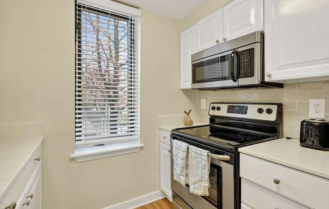 A kitchen with a stove, microwave, and oven.
