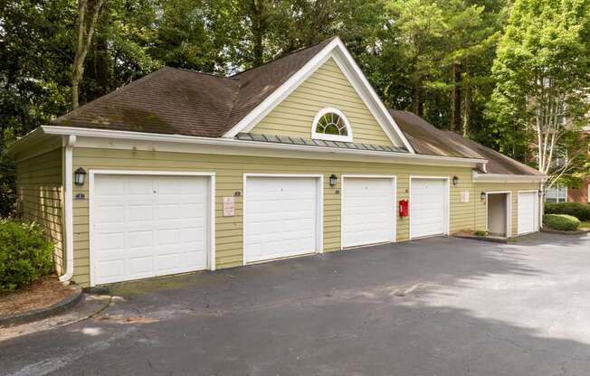 a yellow garage with two white doors and a driveway