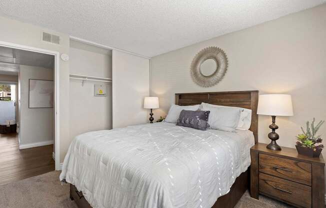 A bedroom with a bed, nightstand, and lamp.