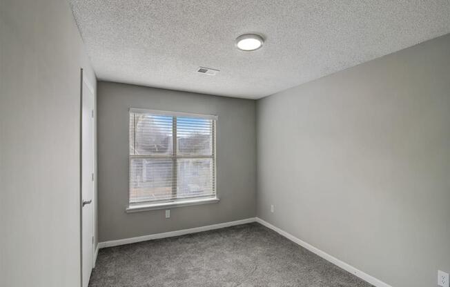 an empty room with a window and carpet at The Sapphire, Decatur, 30035