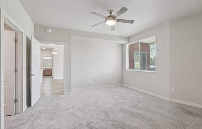 A spacious room with a ceiling fan and carpeted floor.