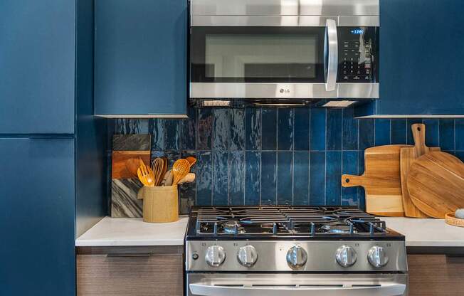 A modern kitchen with a stove, oven, and a microwave mounted above the stove.