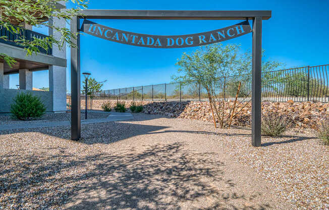 A sign that reads "Uncantada Dog Ranch" stands in front of a fence.