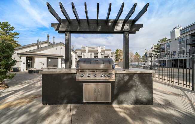 A large black grill is in the foreground of a sunny day.