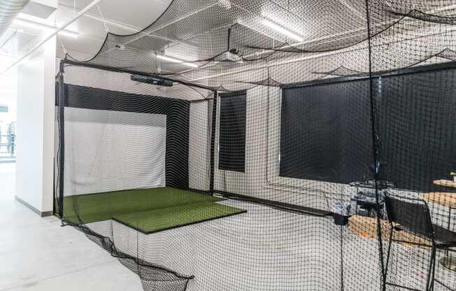 a batting cage in a room with nets and a table at Riverhouse Apartments, Fargo, North Dakota