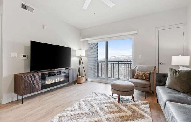 A modern living room with a flat screen TV and a fireplace at Wilmington Flats Apartments, Salt Lake City