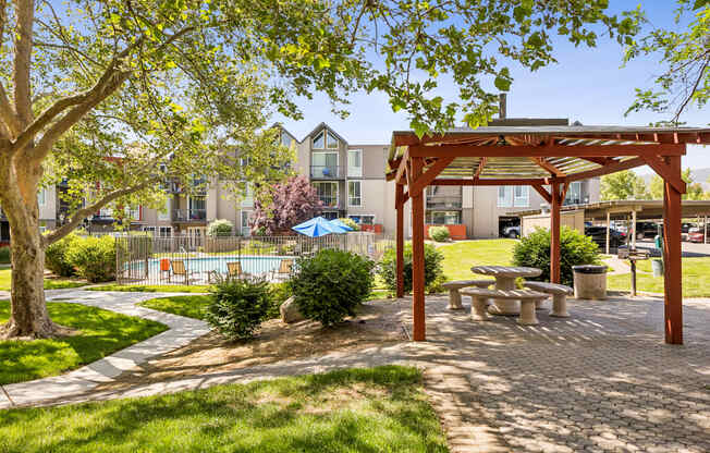 A park area with a picnic table and a tree.