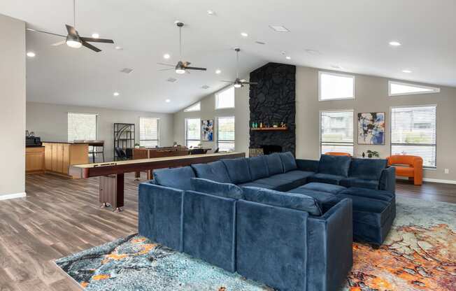 a living room with a blue couch and a pool table