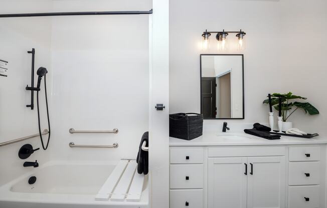 a white bathroom with a tub and a sink and a mirror at The Crossings at Windsong, Prescott Valley, Arizona