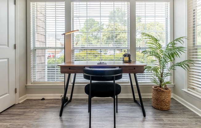 a home office with a desk and chair in front of a window