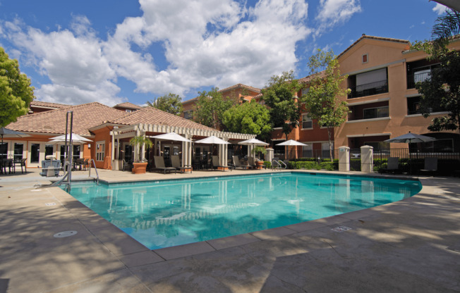 A large swimming pool surrounded by buildings and trees.