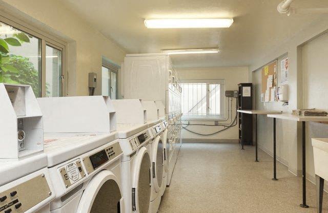 a laundry room with lots of washing machines