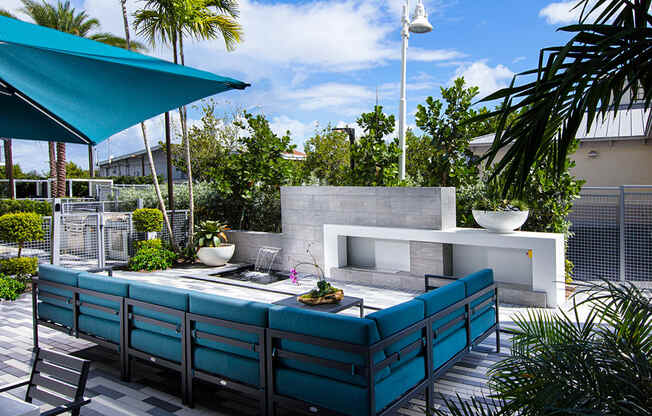 an outdoor entertaining area with turquoise furniture and a fireplace at Saba Pompano Beach, Pompano Beach, 33062