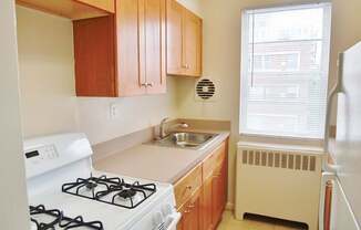 A kitchen with a white gas stove and a white refrigerator.