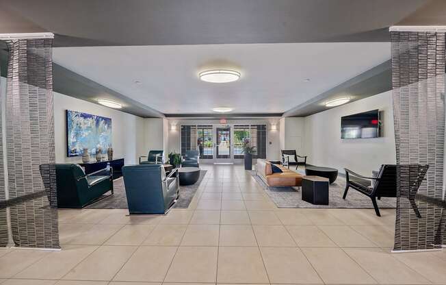 A spacious waiting area with a variety of seating options and a television mounted on the wall.