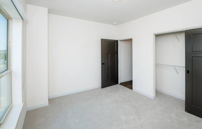 a bedroom with white walls and black doors and a closet at The Crossings at Windsong, Arizona, 86314
