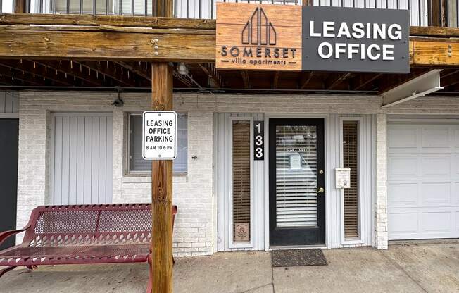 a building with a bench and a leasing office sign