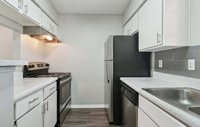 A kitchen with black appliances and white cabinets.