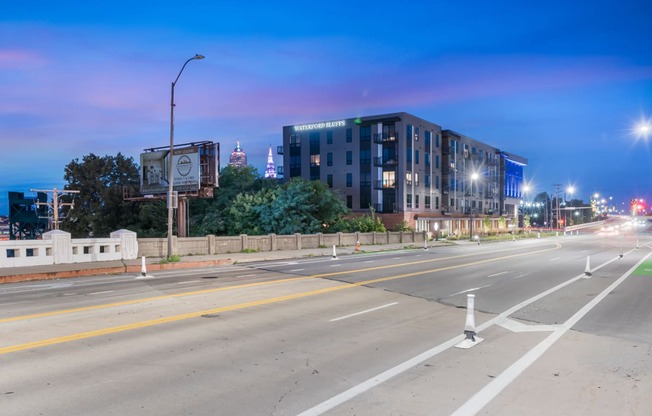 an empty city street at night with a building in the background