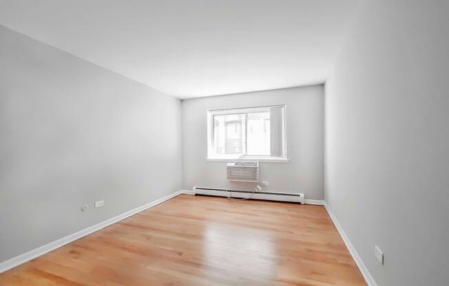 a bedroom with grey walls and a wooden floor