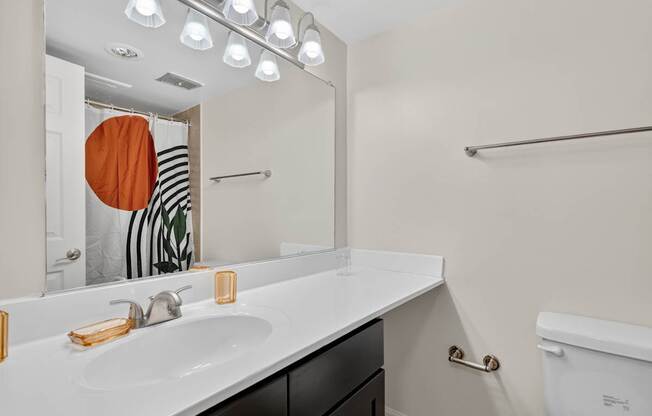 A bathroom with a white sink and a white toilet.