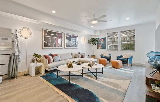 a living room with couches and chairs and a ceiling fan