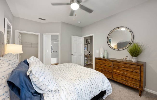 a bedroom with a bed and a dresser and a ceiling fan