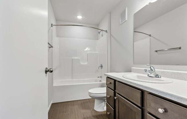 A bathroom with a toilet, sink, and a walk-in shower.