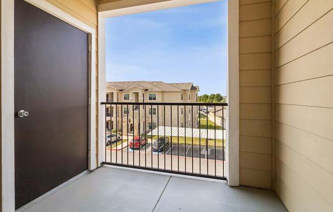 A view from a balcony looking out at a residential street.