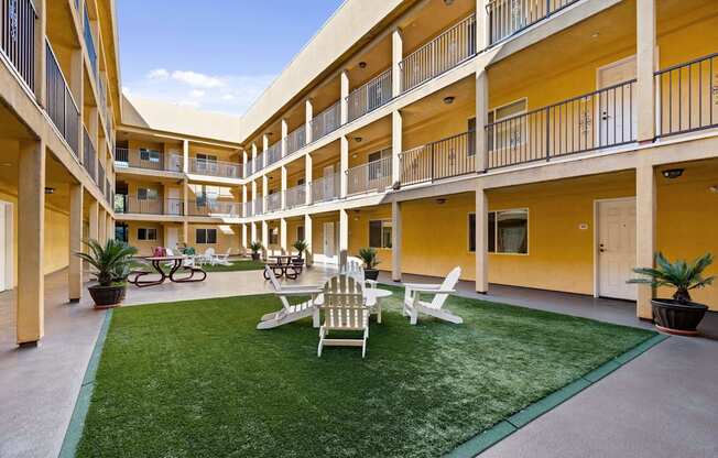 a courtyard with a lawn and chairs and tables at Dronfield Astoria, California, 91342