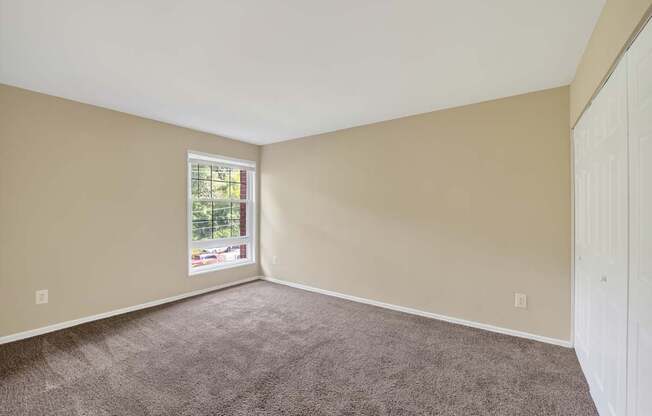 A room with a carpeted floor and a window.