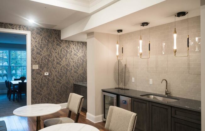 A kitchen with a table and chairs in front of a wall with a pattern.