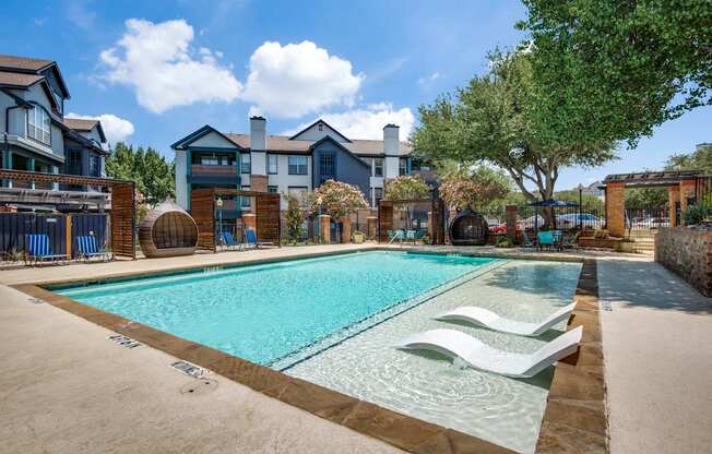 A swimming pool surrounded by a fence and chairs.