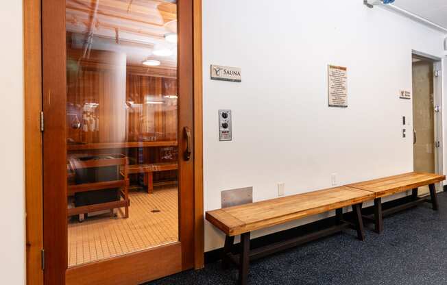 a room with a wooden bench and a glass door