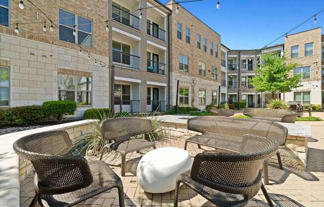 A patio with chairs and a table in front of a building.