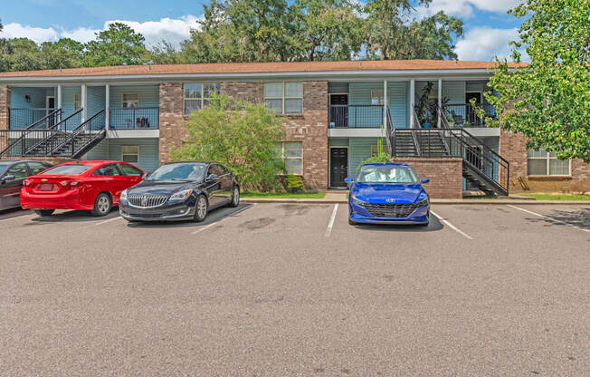 a parking lot with three cars in front of a building