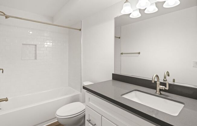 a white bathroom with a sink and a toilet