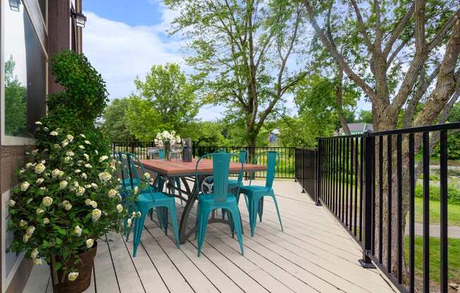 a patio with a table and chairs on a wooden deckat Millcreek Woods Apartments, Kansas, 66061
