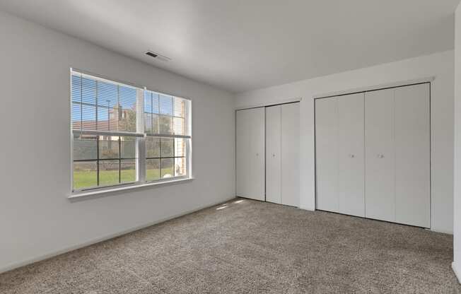 the living room of an apartment with white walls and carpet