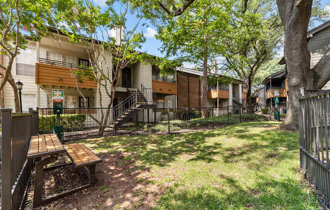 A sunny day at a park with a picnic table and benches.