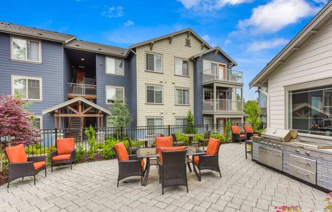 Outdoor Seating Area with Grill, Orange Chairs, Tile Inspired Floor, Blue Apartment Exterior