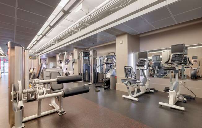 a gym with various machines and weights in a building