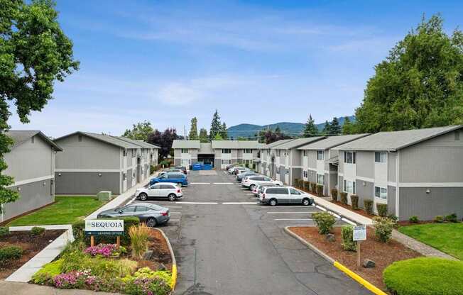 A Sequoia apartment complex with a parking lot in front.